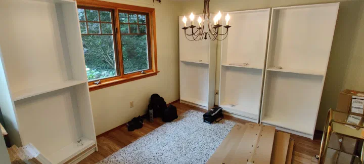 White display cabinets being assembled along a wall