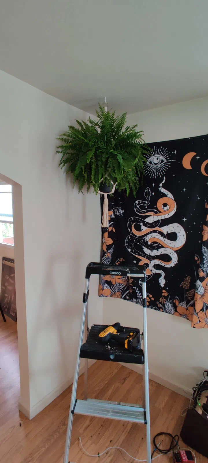 Large textile wall hanging mounted above a sofa